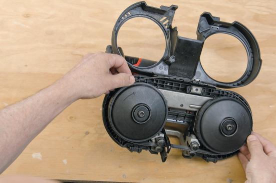 The blade rides between two pairs of guide bearings and can be accessed by popping the latches and opening the cover.