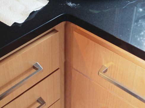The first problem had to do with the drawers on either side of the corner. These slid by each other easily until we installed the pulls; fortunately there was just enough side-to-side adjustment in the slides to gain the necessary clearance.