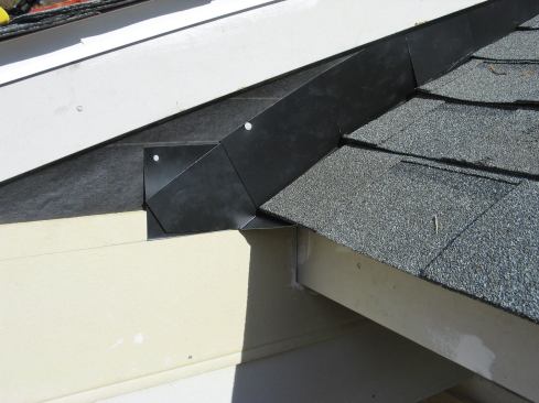 After nailing down the first course of shingles over the starter course, I slipped in the remaining step flashings.