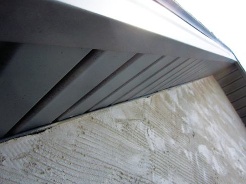At the top of walls, we can bring the rainscreen mat right to the J-bead supporting the soffit.