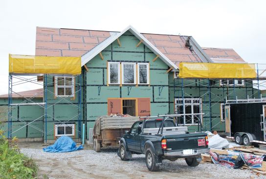 Harnesses may not be needed when there is fully planked staging up to the eaves of a house with guardrails installed as shown. But workers on the cross-gable still need fall protection, because they would be within 6 feet of an unguarded roof edge.