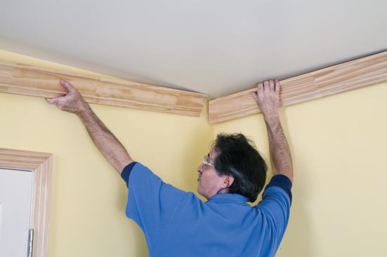 Then, he flexes the first piece away from the wall with his right hand while supporting the last piece in his left hand.