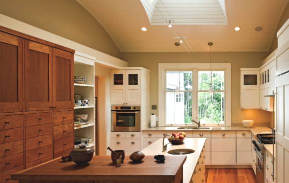 ￼A large central skylight makes this kitchen a magnet for guests and is a boon for cooks with aging eyes.