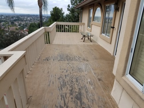 The original deck was dated, and had been jury-rigged with plywood over the decking to divert water away from the ground floor entrance beneath the deck.