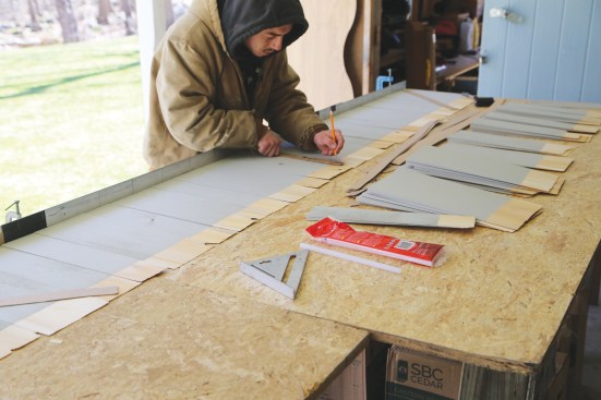 ... a worker marks the shingles for two rows of drywall shims ...