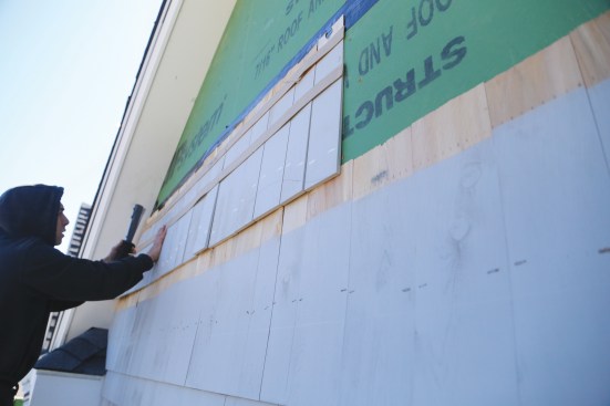 He tack-staples the base course for the first wave course to the wall.