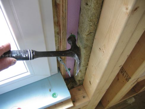 I filled the space between the spreaders at the top and bottom of the windows with 3/4-inch rigid insulation after the windows were set in place. I also placed 1 1/2-by-2-inch rigid insulation to fill voids where the Roxul insulation had been held back.