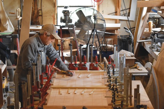 Using shims, the author clamps the veneer to the door frame.